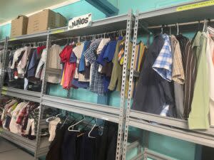  When migrants first arrive at the Sacred Heart Church shelter, they are allowed to pick out their own clothes in the “clothes closet,” which has items for infants, children and adults, donated by the El Paso community. (Ariana Figueroa/States Newsroom)