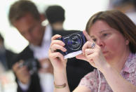 BERLIN, GERMANY - AUGUST 30: Visitors try out the new Samsung Galaxy Camera, which combines a smartphone and a digital camera with a zoom lens, during a press day at the Samsung stand at the IFA 2012 consumer electronics trade fair on August 30, 2012 in Berlin, Germany. IFA 2012 will be open to the public from August 31 through September 5. (Photo by Sean Gallup/Getty Images)