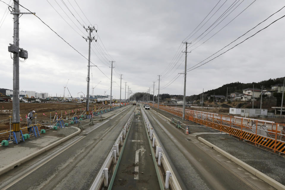 In this March 7, 2016, file photo, a worker checks the construction site in Kesennuma, Miyagi Prefecture, northeastern Japan. (AP Photo/Eugene Hoshiko)