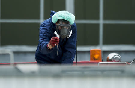 A man wearing a protective mask and suit inspects a container containing eggs and the bodies of culled chickens at a poultry farm, where a highly contagious strain of bird flu was found by Dutch authorities, in Hekendorp November 17, 2014. REUTERS/Marco De Swart