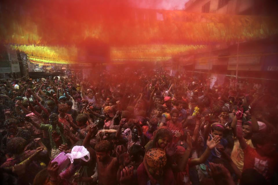 Indians throw colored powder and dance during celebrations marking Holi, the Hindu festival of colors, in Gauhati, India, Monday, March 17, 2014. The holiday, celebrated mainly in India and Nepal, marks the beginning of spring and the triumph of good over evil. (AP Photo/Anupam Nath)