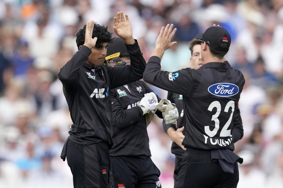 New Zealand's Rachin Ravindra, left, celebrates dismissing England's Dawid Malan during the One Day International cricket match between England and New Zealand at Lord's cricket ground in London, Friday, Sept. 15, 2023. (AP Photo/Kirsty Wigglesworth)