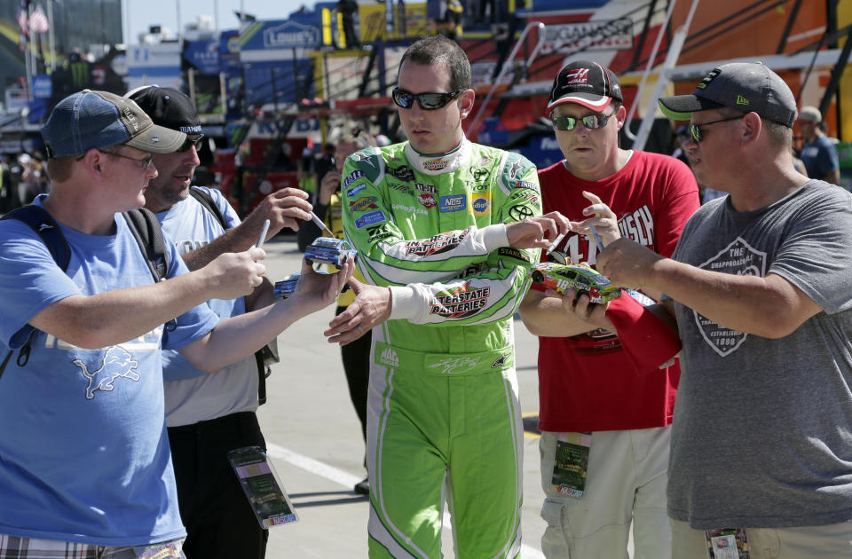 FILE - In this Sunday Oct. 6, 2017, file photo, Kyle Busch signs autographs for fans before practice for a NASCAR Cup Series auto race at Charlotte Motor Speedway in Concord, N.C. Some fans have been coming to the Coca-Cola 600 for decades, but they won’t be allowed into Charlotte Motor Speedwaý on Sunday due to Covid-19, leaving the grandstands empty and many disappointed. (AP Photo/Chuck Burton, File)