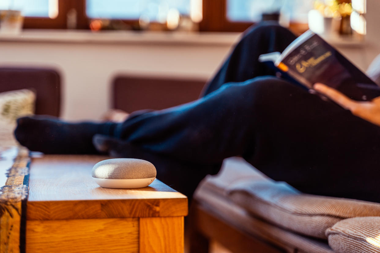 Smart home speaker. Smart home AI device with man reading book in background