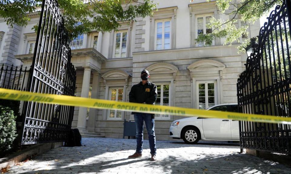 A federal agent stands guard behind a line of police tape outside the property in Washington on Tuesday morning