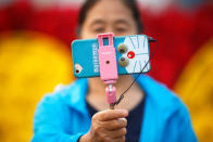 <p>A woman takes pictures of herself as people gather in Tiananmen Square to celebrate National Day marking the 67th anniversary of the founding of the People’s Republic of China, in Beijing October 1, 2016. (REUTERS/Damir Sagolj) </p>