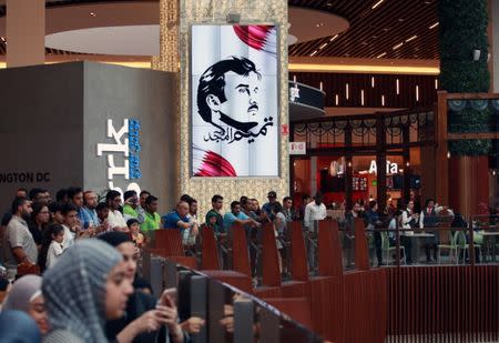 A painting depicting Qatar’s Emir Sheikh Tamim Bin Hamad Al-Thani is seen as people gather to watch players from Spain's national team in Mall of Qatar in Doha, Qatar July 5, 2017. Picture taken July 5, 2017. REUTERS/Naseem Zeitoon NO RESALES. NO ARCHIVES.
