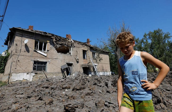 Foto del miércoles de un niño frente a un edificio residencial dañado por los recientes bombardeos en el curso del conflicto entre Ucrania y Rusia en el asentamiento controlado por Rusia de Panteleymonivka en la región de Donetsk
