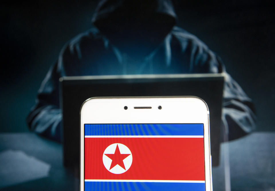 HONG KONG - 2019/04/05: In this photo illustration a democratic People's Republic of Korea, commonly known as North Korea flag is seen on an Android mobile device with a figure of hacker in the background. (Photo Illustration by Budrul Chukrut/SOPA Images/LightRocket via Getty Images)