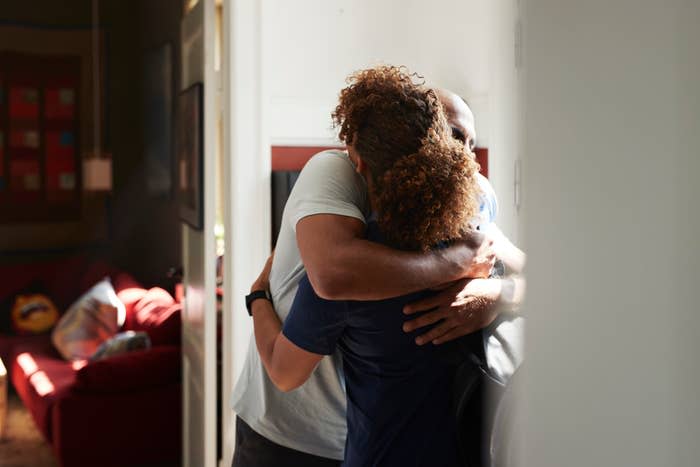 A couple embraces in a warmly lit room, conveying intimacy and affection