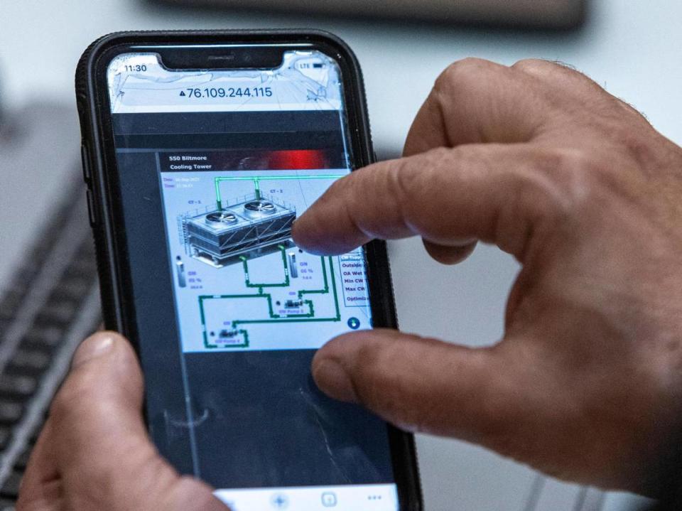 Isel Morfa, building engineer at 550 Biltmore Way, shows members of the University of Miami Industrial Assessment Center the specs for the building’s cooling tower.