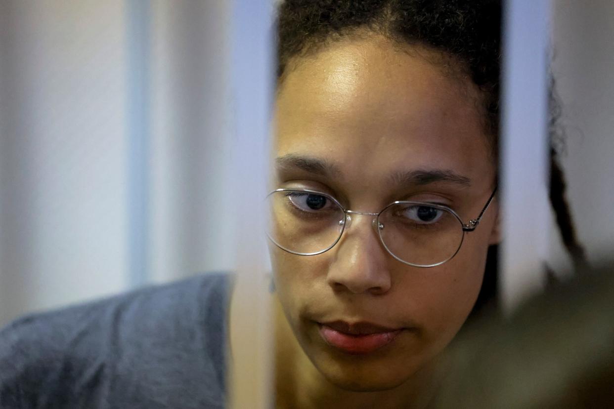 WNBA basketball player Brittney Griner, who was detained at Moscow's Sheremetyevo airport and later charged with illegal possession of cannabis, stands inside a defendants' cage before a court hearing in Khimki outside Moscow, on Aug. 4, 2022.