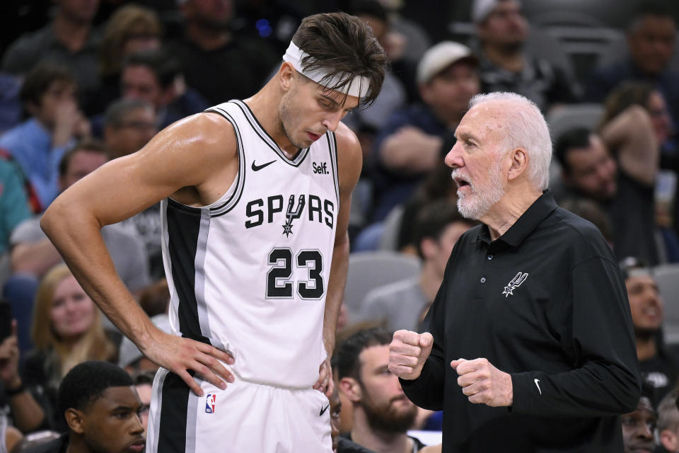 San Antonio Spurs head coach Gregg Popovich, right, speaks with Spurs center Zach Collins during the first half of a preseason NBA basketball game against the Houston Rockets, Wednesday, Oct. 18, 2023, in San Antonio. (AP Photo/Darren Abate)