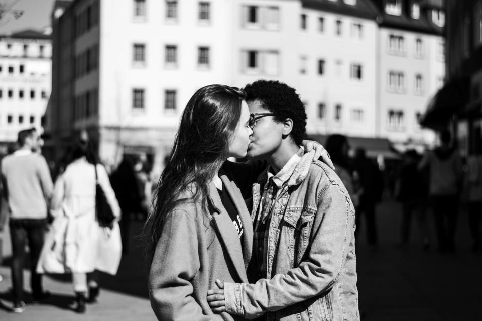 lesbians kissing while standing on city street