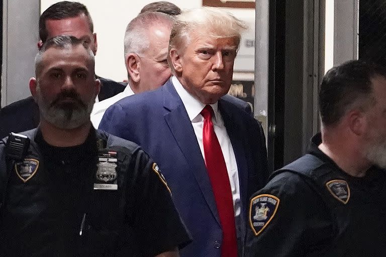 El expresidente Donald Trump es acompañado hacia la sala de un tribunal, el 4 de abril de 2023, en Nueva York. (AP Foto/Mary Altaffer, Archivo)