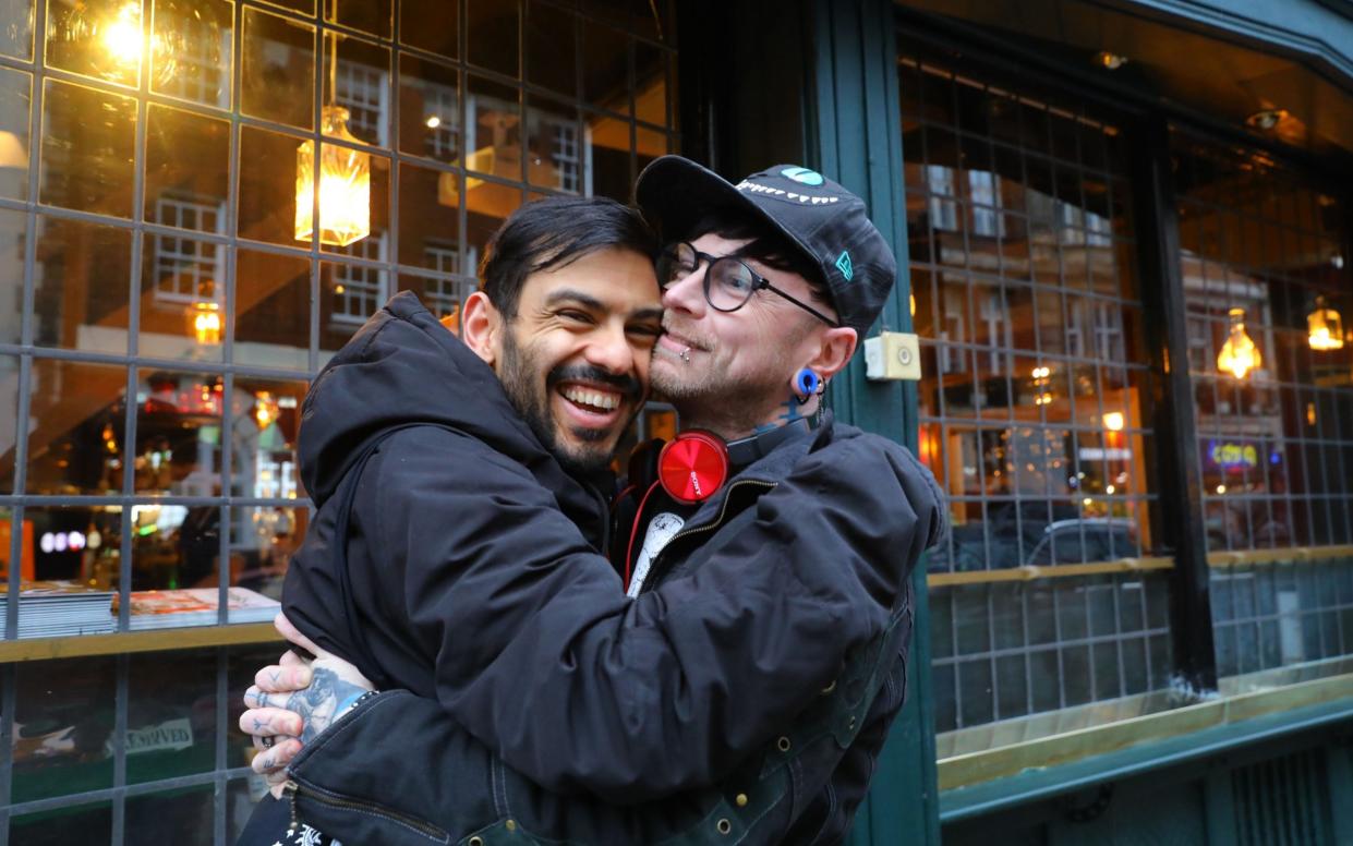 Friends hug outside a restaurant in London as Britain eased some coronavirus restrictions on Monday - VICKIE FLORES/EPA-EFE/Shutterstock