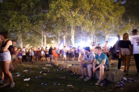 Shane Wallace (R) sits on a rock after the final Kanye West performance as hundreds of other attendees depart from the Made in America festival in Philadelphia, August 30, 2014. REUTERS/Mark Makela