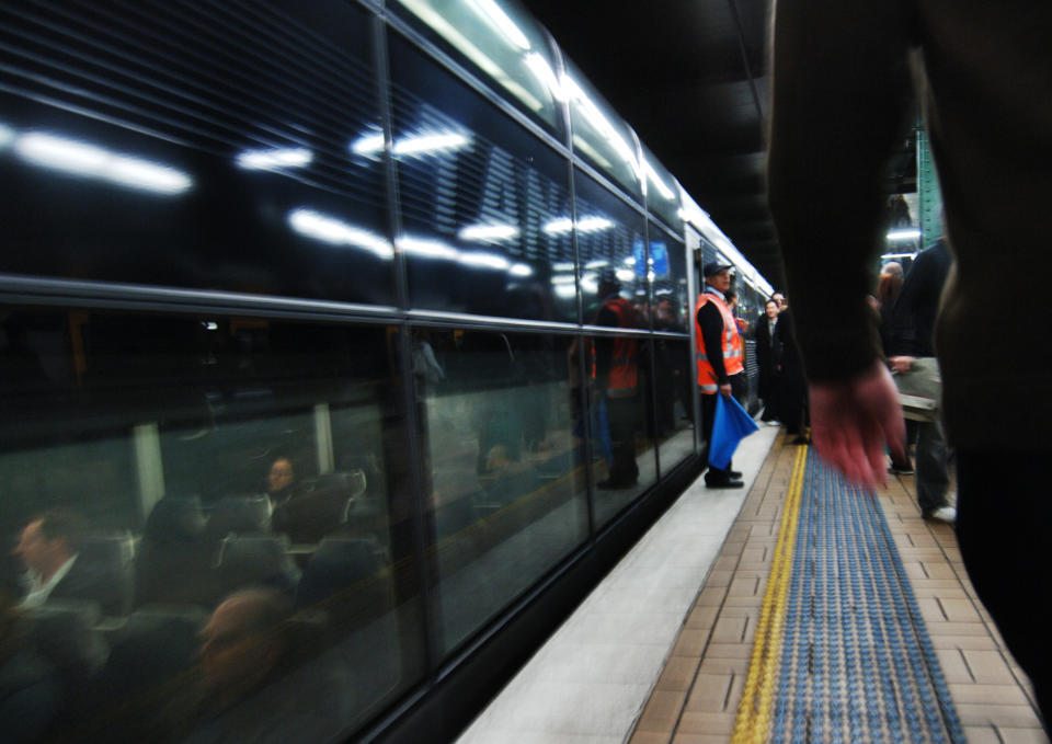 A City Rail guard waits at a train platform. 