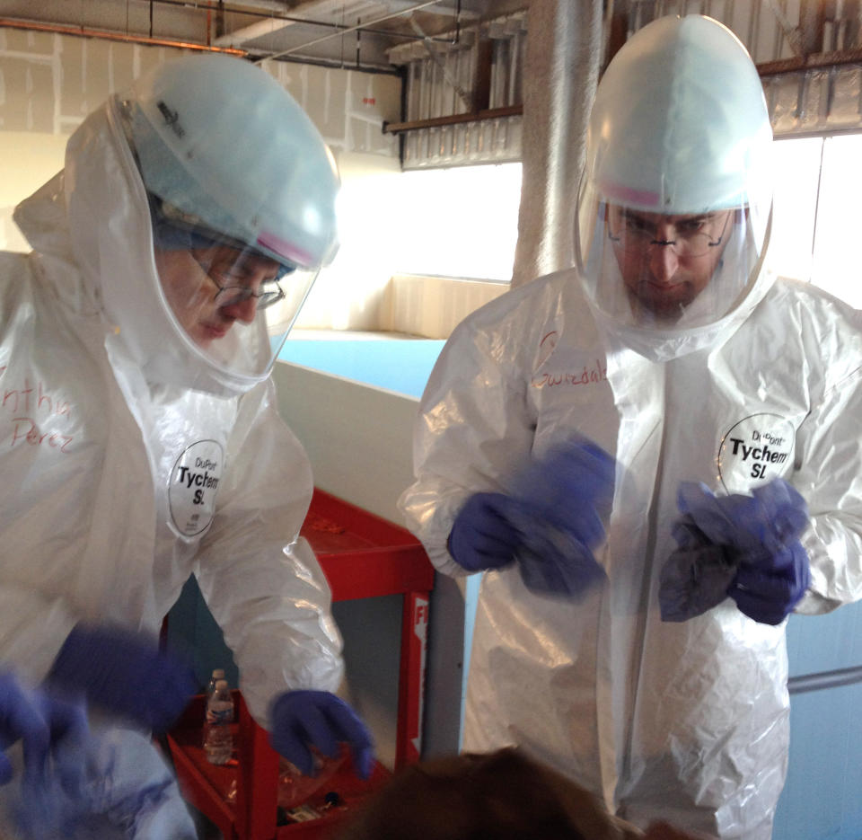 In this Monday, Oct. 6, 2014, photo Dr. Michael OâConnor , left, and Dr. Mark Nunnally, learn how to use personal protective gear during Ebola preparedness training at the University of Chicago. U.S. hospitals are preparing for possible Ebola patients; the only one diagnosed so far in this country is being treated in Texas, while the outbreak in Africa has killed more than 3,400 people. (AP Photo/Lindsey Tanner)