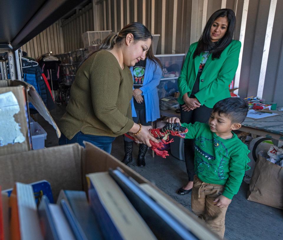 Joanna Lopez, left, looks at toys her son, Macario Montes-Lopez received on this trip to the Grassroot Projects storage facility Monday, Nov. 7, 2022 in Carmel. Grassroot Projects ​Program Coordinator Rosana Marin and Co-Founder and President Priya Gangwani, right, look on. The small nonprofit organization helps children of immigrant and refugee families.