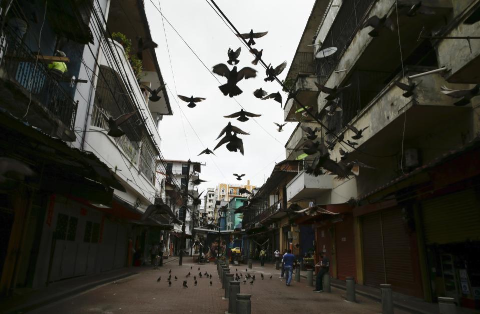 Unas palomas vuelan en una peatonal del centro de la capital panameña, el martes 14 de julio del 2020. El país centroamericano vive un repunte sostenido de los casos del nuevo coronavirus, lo que tiene al gobierno evaluando endurecer el confinamiento en la capital y otras zonas con los mayores contagios. (AP Foto/Arnulfo Franco)