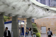 <p>People cool down under the cooling mist spot in Tokyo, Monday, July 13, 2018. (Photo: Koji Sasahara/AP) </p>