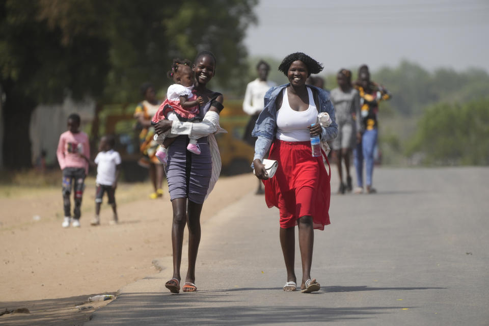 Varias personas caminan por una calle de Yuba, Sudán del Sur, mientras la comitiva del papa Francisco pasa en dirección a la Catedral de Santa Teresa para un encuentro con religiosos el 4 de febrero de 2023. (AP Foto/Gregorio Borgia)