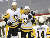 Pittsburgh Penguins center Colton Sceviour (7) celebrates his goal with left wing Radim Zohorna (67) and center Mark Jankowski (14) during the second period of an NHL hockey game against the New Jersey Devils, Friday, April 9, 2021, in Newark, N.J. (AP Photo/Bill Kostroun)