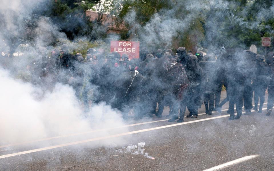 Counter-protesters retreat amidst smoke from incendiary devices - REUTERS