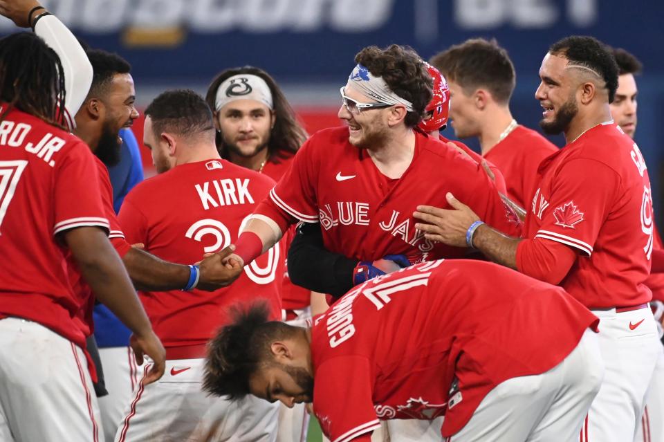 Danny Jansen, center, celebrates with teammates after hitting a walk-off single in the 11th inning to defeat the Chicago Cubs during a game Aug. 29 in Toronto.