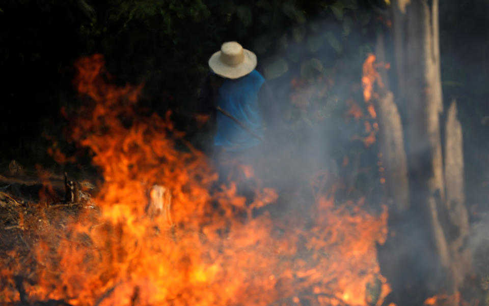 A man works in a burning tract of Amazon jungle as it is being cleared by loggers and farmers in Iranduba, Amazonas state, Brazil Aug. 20, 2019. (Photo: Bruno Kelly/Reuters)