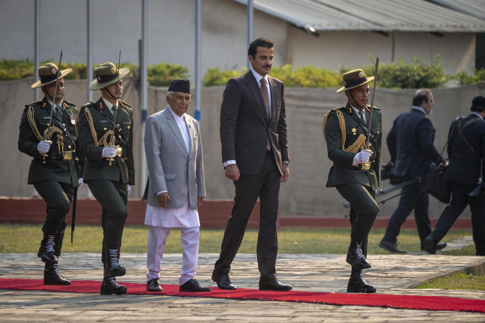 Qatar's Emir Sheikh Tamim bin Hamad Al Thani, center right, walks with Nepal's President Ram Chandra Poudel, center right as he receives guard of honor at his arrival at the airport in Kathmandu, Nepal, Tuesday, April 23, 2024. The emir is on a two-days visit to the Himalayan nation. (AP Photo/Niranjan Shreshta)