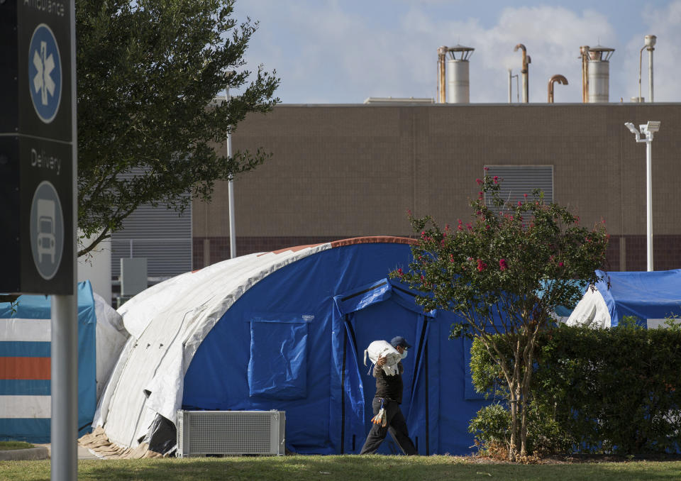 A construction crew works to set up tents that hospital officials plan to use with an overflow of COVID-19 patients outside of Lyndon B. Johnson Hospital, Monday, Aug. 9, 2021, in Houston. (Godofredo A. Vásquez/Houston Chronicle via AP)