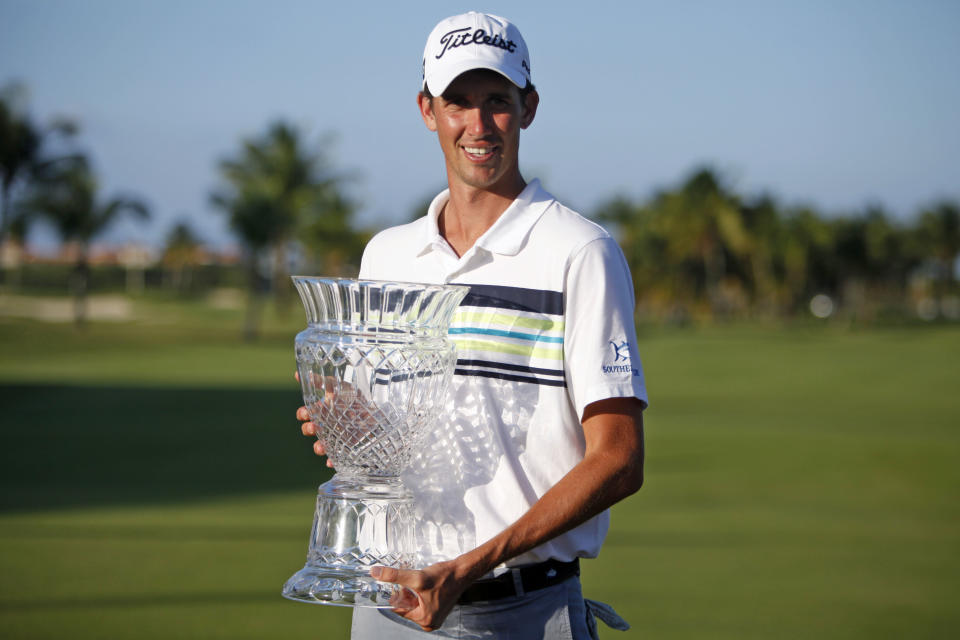 U.S. Chesson Hadley poses for pictures with his Puerto Rico Open PGA golf trophy after winning the tournament in Rio Grande, Puerto Rico, Sunday, March 9, 2014. (AP Photo/Ricardo Arduengo)