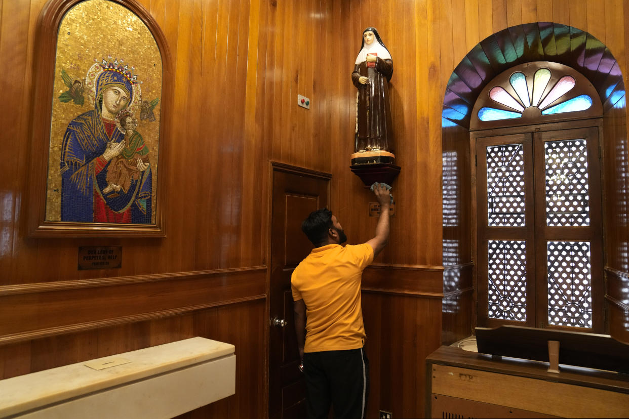 A worker cleans a statue of Virgin Marry, at the Sacred Heart church in preparation of a papal visit, in Manama, Bahrain, Wednesday, Nov. 2, 2022. Pope Francis is making the November 3-6 visit to participate in a government-sponsored conference on East-West dialogue and to minister to Bahrain's tiny Catholic community, part of his effort to pursue dialogue with the Muslim world. (AP Photo/Hussein Malla)