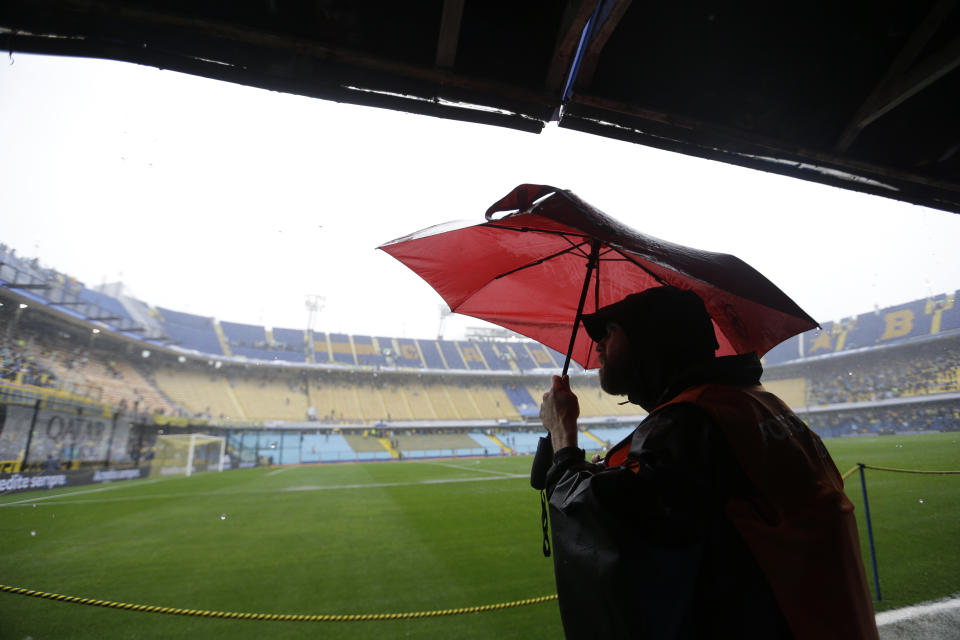 Un periodista observa la lluvia en el estadio la Bombonera en Buenos Aires, Argentina, el sábado 10 de noviembre de 2018. La final de la Copa Libertadores entre Boca Juniors y River Plate fue pospuesta por lluvia. (AP Foto/Natacha Pisarenko)