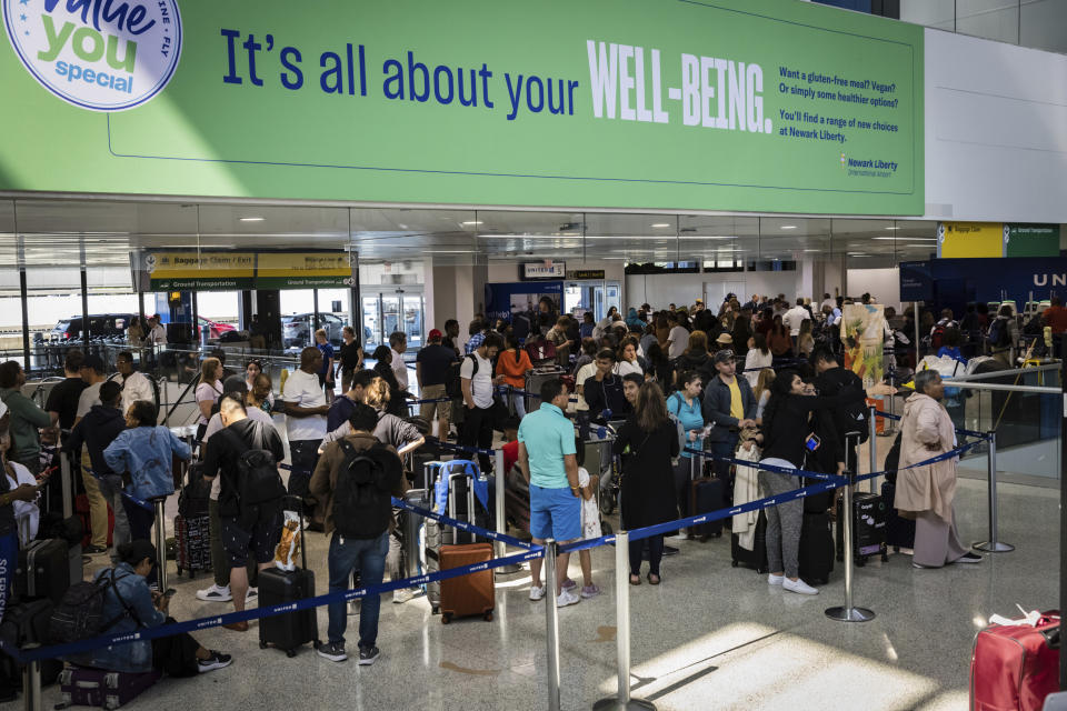 Delayed travelers wait in line to check in at the United Airlines ticket desk at Terminal C in Newark International Airport in Newark, N.J., Wednesday, June 28, 2023. Airline passengers face delays following flight cancellations due to storms in the region. (AP Photo/Stefan Jeremiah)