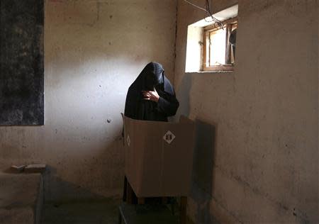 A veiled Muslim woman casts her vote inside a polling station in Doda district, north of Jammu April 17, 2014. Around 815 million people have registered to vote in the world's biggest election - a number exceeding the population of Europe and a world record - and results of the mammoth exercise, which concludes on May 12, are due on May 16. REUTERS/Mukesh Gupta