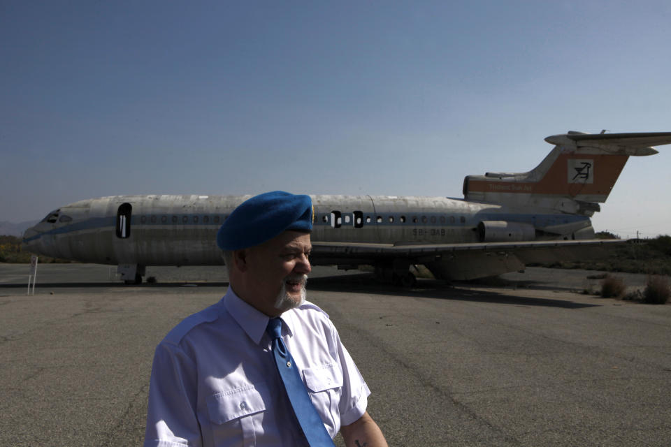 Canadian veteran soldier Gary Best who has served with the United Nations Peacekeeping force on war-divided Cyprus stands in front of an abandoned passenger aircraft, at the derelict Nicosia airport located inside the UN-controlled buffer zone on the capital's outskirts on Tuesday, March 18, 2014. A gutted Cyprus Airways Trident passenger jet a stone’s throw away from the terminal serves a reminder of the fierce battles that had raged there in July, 1974. Advancing Turkish forces had tried to seize the strategically important airport on the capital’s western outskirts, hours in to their invasion of Cyprus that was triggered by a coup aimed at uniting the island with Greece. Canadian soldiers then serving with the United Nations Peacekeeping force in Cyprus _ or UNFICYP _ helped repel the advance. Since then, it’s been the force’s headquarters midway through a 180 kilometer (112 mile) buffer zone that splits this ethnically divided island into a breakaway Turkish Cypriot north and a internationally recognized, Greek Cypriot south. (AP Photo/Petros Karadjias)