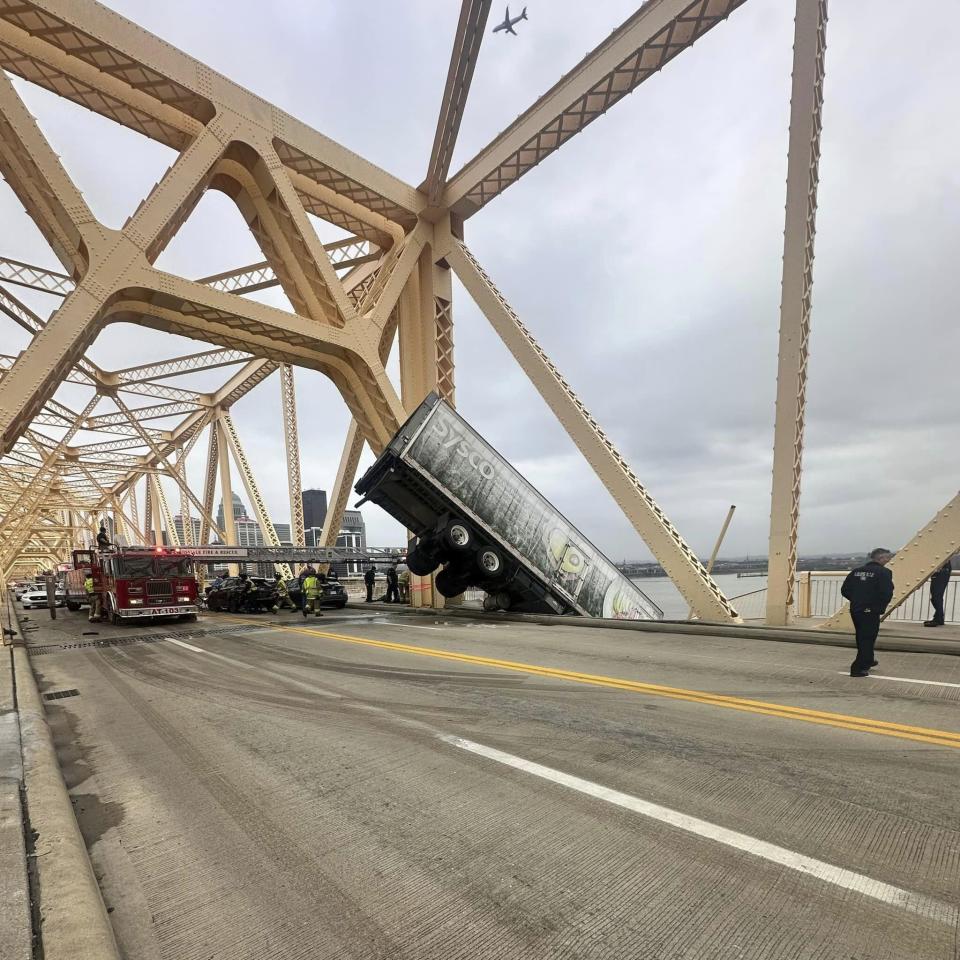 This photo provided by Louisville Division of Fire, Louisville Fire Dept. rescue the driver of semitruck that is dangling off the Clark Memorial Bridge over the Ohio River on Friday, March 1, 2024 in Louisville, Ky. The driver was pulled to safety by firefighters following the three-vehicle crash on the bridge connecting Louisville, Kentucky to southern Indiana(Louisville Division of Fire via AP)