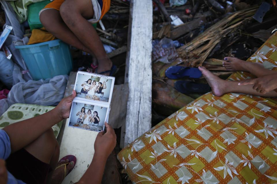 A survivor looks at a family photo album which was retrieved from the ruins of his home, which was destroyed by Super Typhoon Haiyan, in Palo