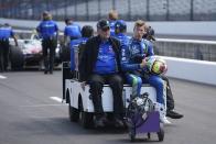 Sting Ray Robb, right, rides on the back of a cart during qualifications for the Indianapolis 500 auto race at Indianapolis Motor Speedway, Saturday, May 20, 2023, in Indianapolis. (AP Photo/Darron Cummings)