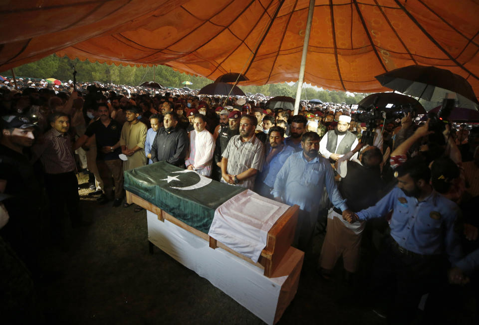 People attend the funeral prayer for Pakistani nuclear scientist Abdul Qadeer Khan, in Islamabad, Pakistan, Sunday, Oct. 10, 2021. Khan, a controversial figure known as the father of Pakistan's nuclear bomb, died Sunday of COVID-19 following a lengthy illness, his family said. He was 85. (AP Photo/Anjum Naveed)