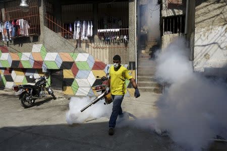 A municipal worker fumigates the Petare slum to help control the spread of the mosquito-borne Zika virus in Caracas, February 3, 2016. REUTERS/Marco Bello