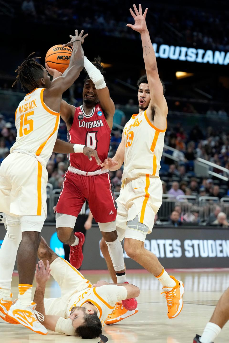 Louisiana guard Themus Fulks (0) shoots against Tennessee guard Jahmai Mashack (15), forward Olivier Nkamhoua (13) and guard Santiago Vescovi, bottom, during the first half of a first-round college basketball game in the NCAA Tournament Thursday, March 16, 2023, in Orlando, Fla. (AP Photo/Chris O'Meara)