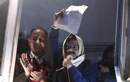 Delhi's Chief Minister Arvind Kejriwal, chief of the Aam Aadmi Party (AAP), shows his resignation to his supporters while addressing them from his party headquarters in New Delhi February 14, 2014. REUTERS/Adnan Abidi
