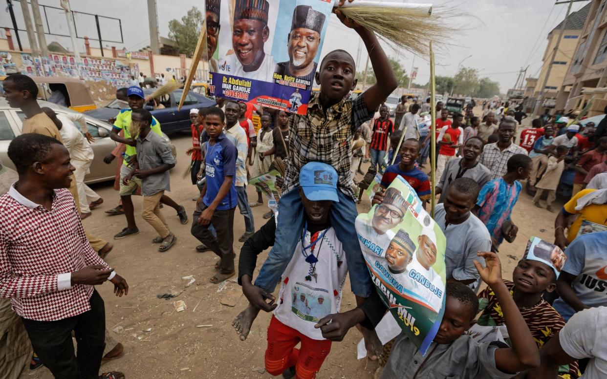 Supporters of Nigeria's President Muhammadu Buhari march to celebrate his electoral win - AP