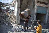 A man carries a barrel as people collect steel from a destroyed building in Mosul, Iraq April 17, 2017. REUTERS/Marko Djurica