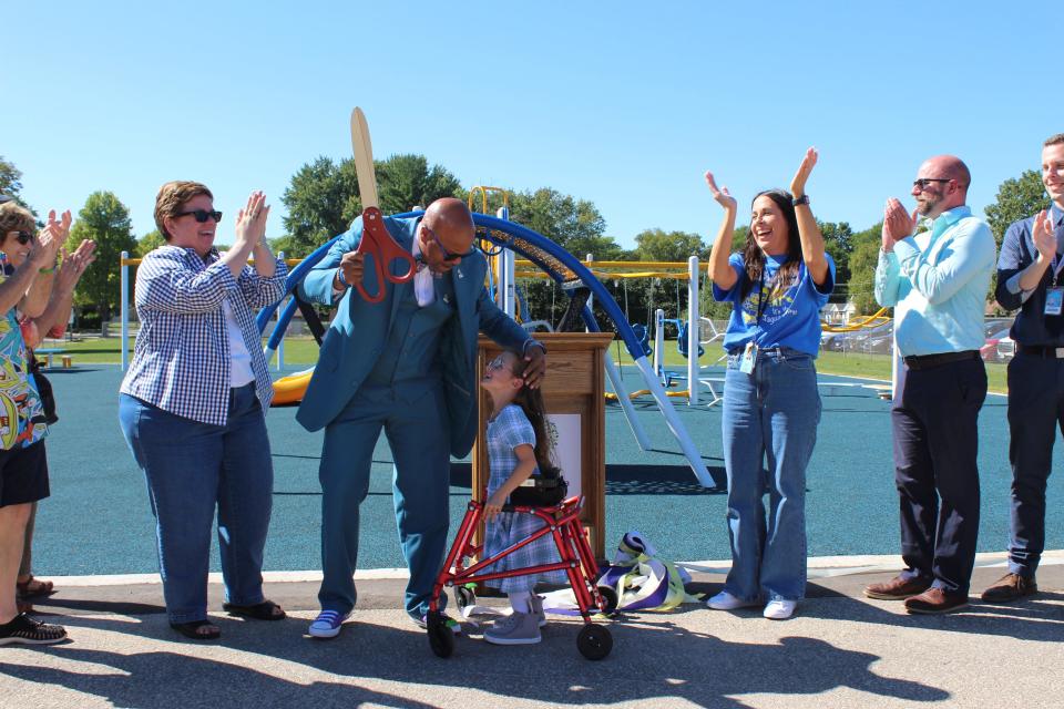 Green Bay School Board President Laura McCoy, Superintendent Claude Tiller, student Winter, Jackson Elementary Principal Kate Dolan and Mayor Eric Genrich celebrate the opening of Jackson Elementary's new playground on August 30, 2023 in Green Bay.
