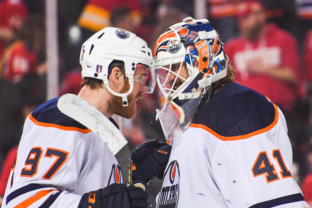 CALGARY, AB - MAY 20: Connor McDavid #97 (L) and Mike Smith #41 of the Edmonton Oilers celebrate after defeating the Calgary Flames in Game Two of the Second Round of the 2022 Stanley Cup Playoffs at Scotiabank Saddledome on May 20, 2022 in Calgary, Alberta, Canada. The Oilers defeated the Flames 5-3. (Photo by Derek Leung/Getty Images)